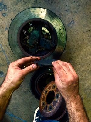 A technician explains the wear on a brake pad over a rotor.