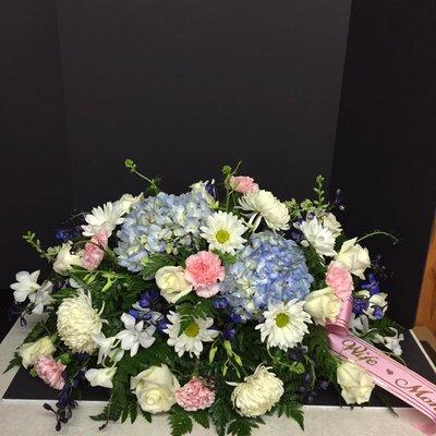 Blue & white casket spray with a couple pops of pink