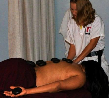 Massage student practices Hot Stone therapy