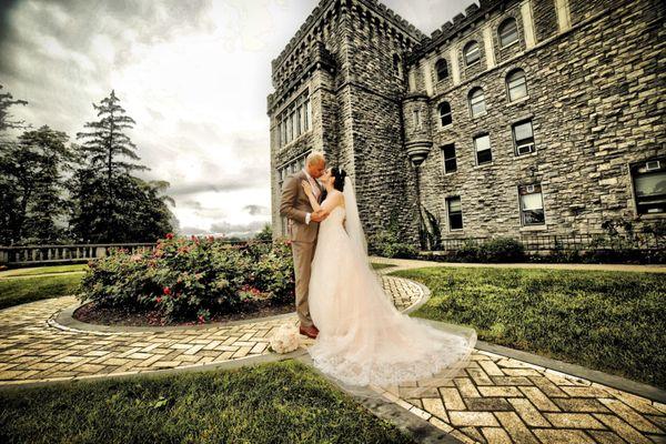 Bride and groom kissing in front of Reid Castle