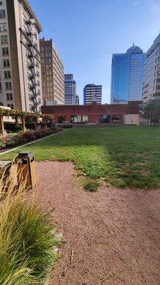 Rooftop garden, with covered tables, chairs, a grill, patio, flowers, and Grass!