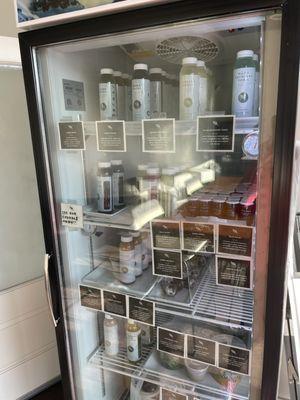 Refrigerator filled with juices, salads, & more