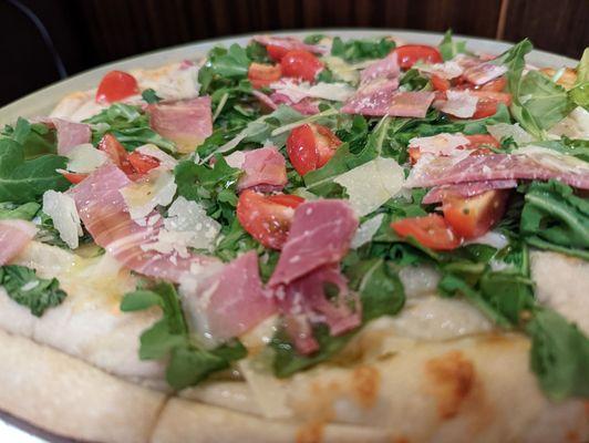 L'antonia. Garlic pizza with Arugula, tomato and prosciutto