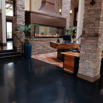 Lobby desk, with an extra long fireplace behind the check-in desk.