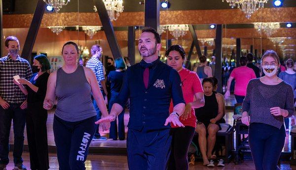 Instructor leads a group salsa class