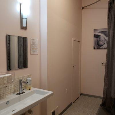 Women's room has a shower area and enclosed commode.