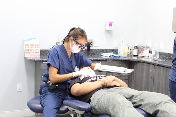 Dr. Lindsey Pikos Rosati, a board-certified periodontist, exams a patient for periodontitis, or gum disease.