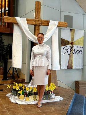 Pastor Narcissis after her beautiful Easter Service. The cross now stands draped in white because "He has risen, indeed!"