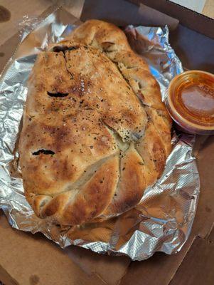 Calzone with chicken, mushroom, onion, bacon and spinach.