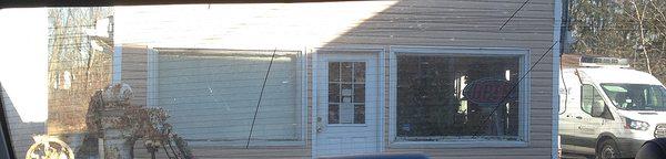 Front of Cafe Pierrot, Andover - rotting window sills - and rusting mill in front.   Why the neglect of outside & inside?