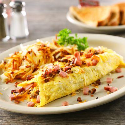 Texas Omelet - Stuffed with bacon, sausage, diced ham and American cheese, topped with Cheddar and Monterey Jack cheese.