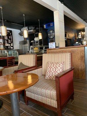 Comfy chairs, view of baked goods and kitchen area