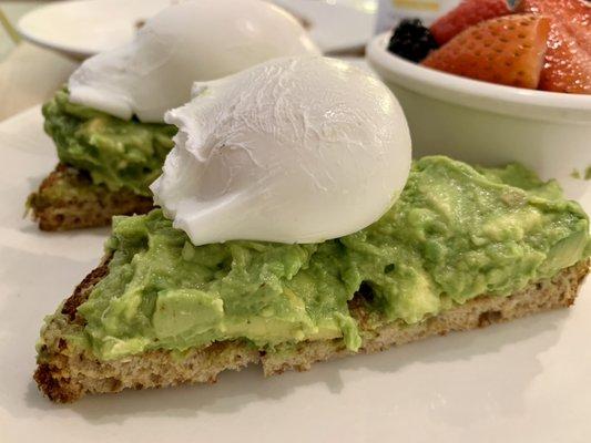 Avocado toast served with two eggs any style and fruit