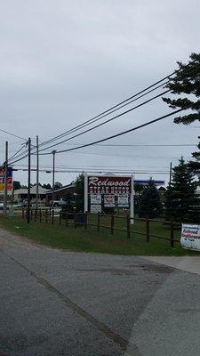 A great sign advertising the Redwood Steakhouse at the corner, going into town at traffic light