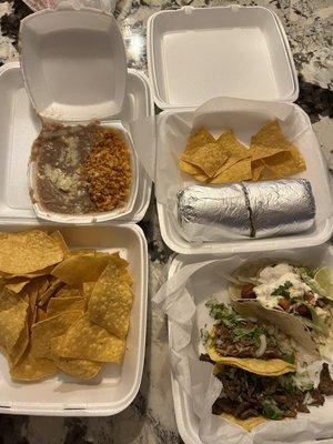 Three tacos, burrito, chips and  rice & beans