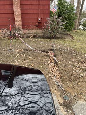 Caution tape and trench extending to the neighbor's property