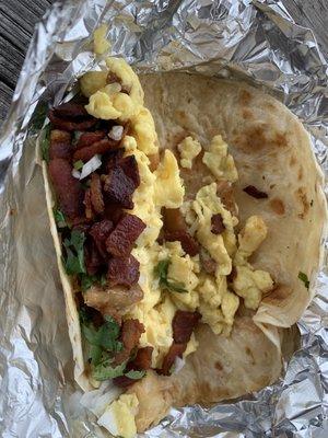 Bacon, egg, and potato breakfast "taco" with cilantro and onions