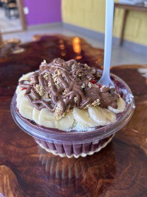 Açaí bowl with banana, strawberry, Nutella, coconut shavings, passion fruit mouse, granola