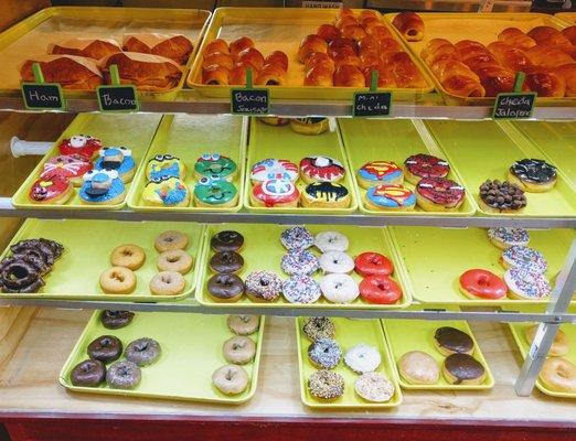 Display of breakfast choices.  Look at all the fun superhero and cartoon doughnuts.