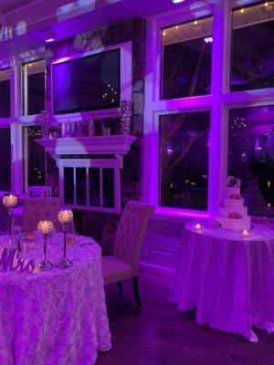 Window in Milburn Room overlooking pond, with fireplace and cheerful lighting