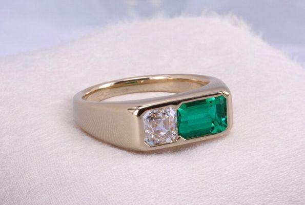 Carl Blackburn custom made engagement ring featuring a 1 carat Asscher Cut diamond and a 2 carat Emerald.