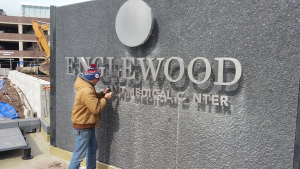 Hardworking member of the GDS team installing an exterior sign!