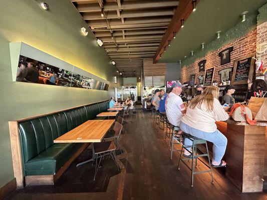 The interior with booths along wall and spots at the bar to eat