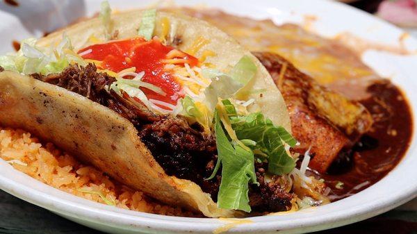 Beef taco with enchilada and rice and beans.