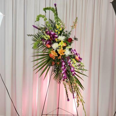 Modern spray for memorial with lilies, orchids, roses, gladioli and greenery.