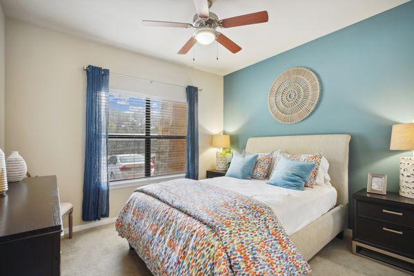 Secondary bedroom with plush carpet and ceiling fan