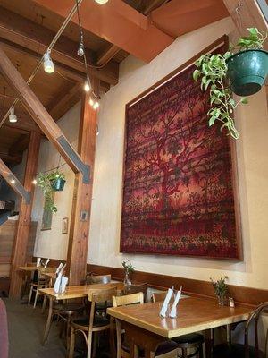 Inside: high ceilings, thick wood beams, earthy tapestries and plants