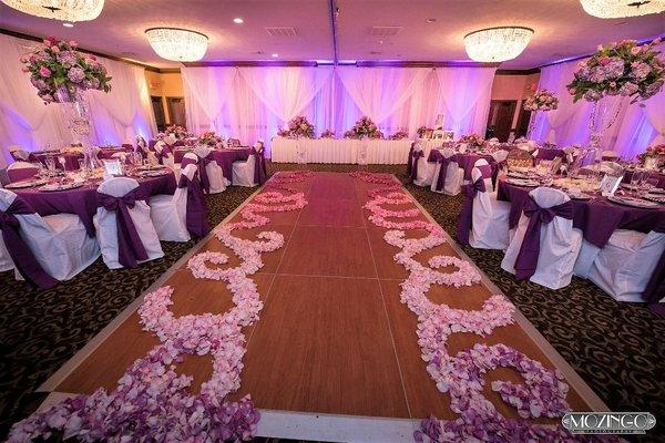 A beautiful indoor reception, with dance floor, linens, white sheers and uplighting!