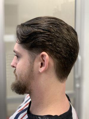 Tapered cut primarily scissor over comb. Styled with hair tonic with oil.