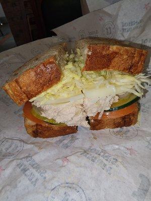 Tuna club with cheese, cucumbers,  pickles and tomatoes,  lettuce on wheat bread