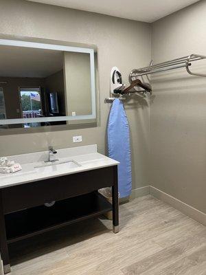 Ironing board, iron, clothes hang area and large vanity w/comp soap.