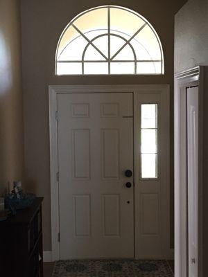 Inside view of from door and arched window.