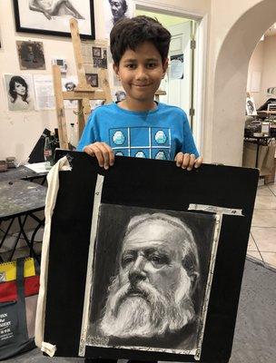 Akshay (10), one of our most talented students at age 10, with his charcoal portrait drawing