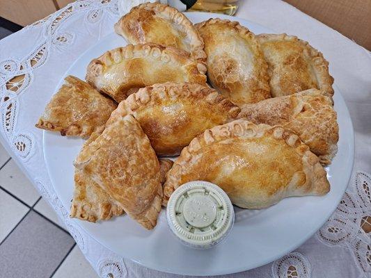 Assorted flavors of empanadas with sauce