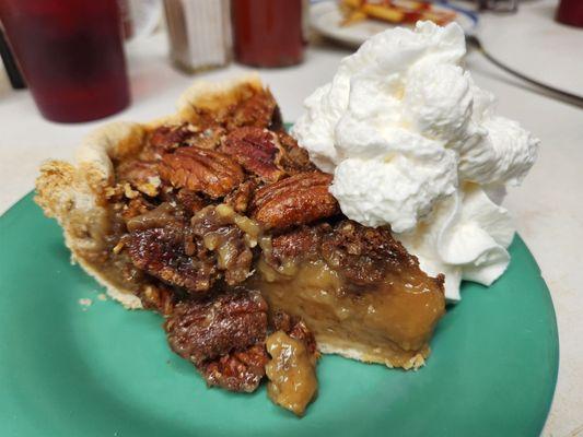 Housemade pecan pie with a dollop.