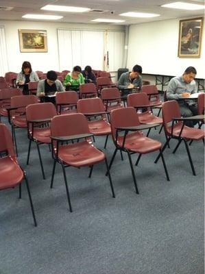 A classroom, students taking an exam.