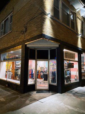 The storefront of Happy Hour Vintage taken at night.