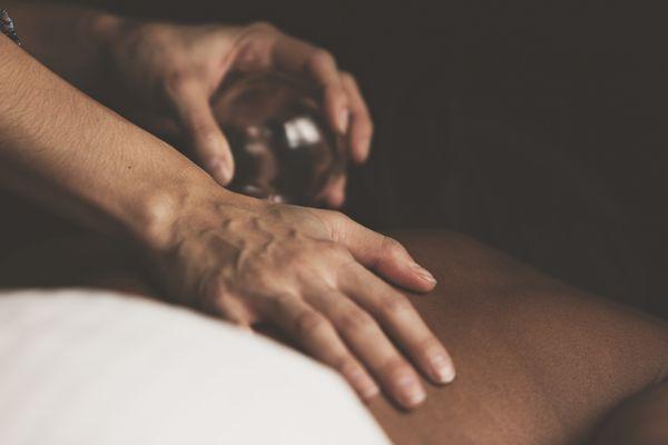 Janaye using cupping to treat a patient for shoulder pain and muscle tension.