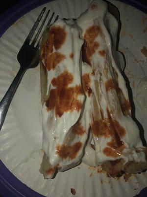 One pork and one chicken tamale with sour cream and hot sauce