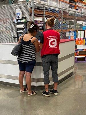 This Costco worker was showing photos from her phone to a customer/friend for 10 minutes while people were waiting to be helped.