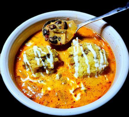 Chile relleno with green chile rice balls. Roasted poblano peppers, onions, garlic, black beans, chicken with a spicy enchilada broth