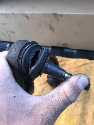 Upper ball joint with a torn boot.