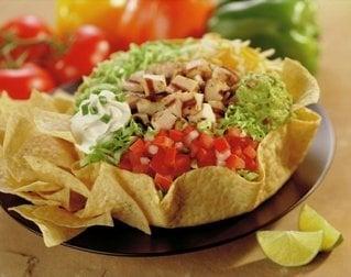 Taco Salad- a crispy tortilla shell stuffed with romaine lettuce, savory rice, beans, salsa, guacamole, cheese & sour cream.