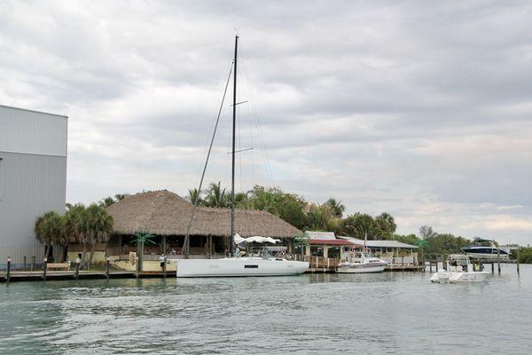 Pop's with a big sail boat at dock