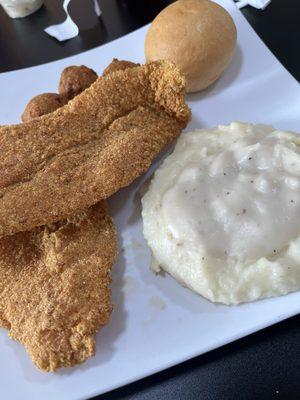 Catfish fillets, mashed potatoes and gravy, hush puppies and roll.