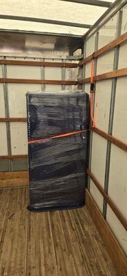 The refrigerator was meticulously wrapped and protected to ensure its safety during transit.